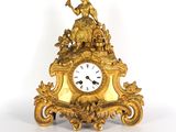 une horloge en or surmontée d'une statue