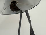 a metal sculpture of a bird with a mirror on it ' s head