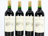 three bottles of red wine are lined up on a white surface