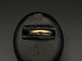 un gros plan d'un bouton noir orné d'un anneau doré
