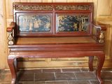 un banc en bois dont le dossier est orné d'une peinture