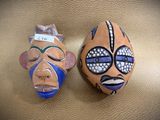 two masks that are sitting on a gold surface