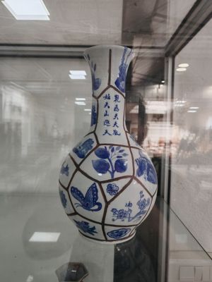 un vase bleu et blanc exposé dans une vitrine