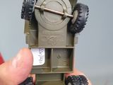 a person holding a toy army vehicle in their hand