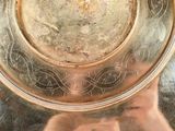 a person holding a silver plate in front of their face