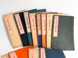 several books with chinese writing are lined up on a white surface