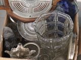 une boîte remplie de verrerie posée par terre