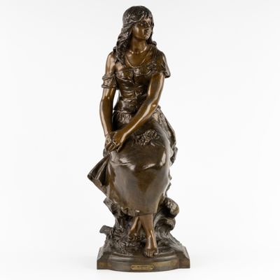 une statue en bronze d'une femme assise sur un rocher