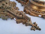 two antique clocks sitting on a table next to each other