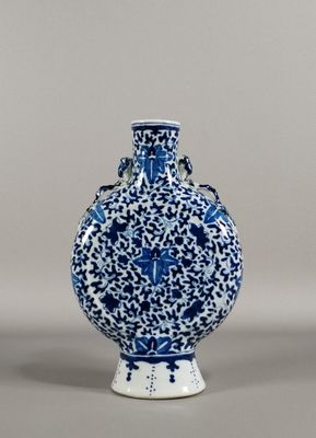 blue and white vase with a bird on it on a gray surface