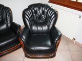 two black leather chairs sitting next to each other in a room