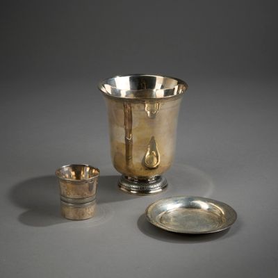une coupe en argent et une assiette en argent posées sur une table
