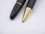 pair of black and gold ballpoint pens sitting on a white surface