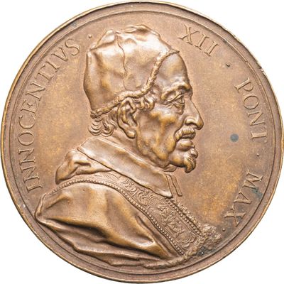 un gros plan d'une médaille sur laquelle figure un homme coiffé d'un chapeau