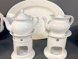 a lot of white dishes and cups sitting on a table