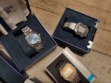 three watches in a box on the floor next to each other