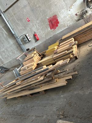 de nombreuses pièces de bois empilées sur le sol du garage