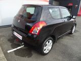 a small black car that is parked in a parking lot