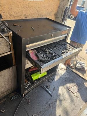 un homme debout à côté d'un barbecue contenant des ustensiles