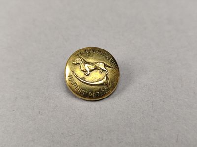 un gros plan sur un bouton doré orné d'un cheval