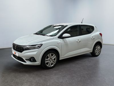 Une voiture blanche est garée dans une pièce blanche au sol noir.