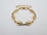 un bracelet en or au motif torsadé sur fond blanc