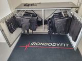 an image of a room with a bunch of clothes hanging on a rack