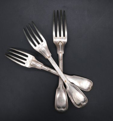 three forks and two spoons on a black surface