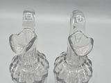 two clear glass vases sitting next to each other