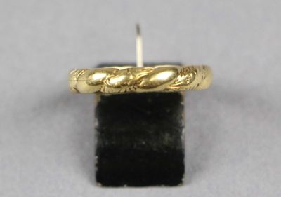 gros plan d'une bague en or sur une surface noire