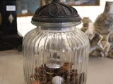 a glass jar filled with coins and a bird on top of it
