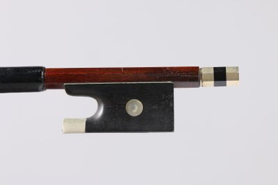a close up of a violin bow with a piece of wood sticking out of it
