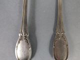 two spoons and a fork are sitting on a table
