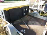 a trailer with a trailer attached to it in the grass