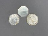 trois éléments en argent et en nacre sur un fond gris