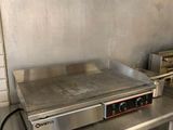 plan de travail en acier inoxydable dans une cuisine professionnelle équipée d'une plaque de cuisson électrique