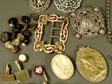 many different types of brooches and jewelry on the table
