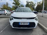 the front view of a white car parked in a parking lot