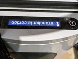 a close up of a coffee maker with a blue screen on it