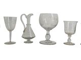 cinq verres à vin et un pichet sur fond blanc
