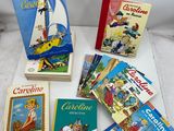 Plusieurs livres pour enfants sont posés sur une table devant un fond blanc.