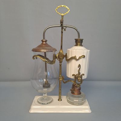 un vase blanc et un verre posés sur un support