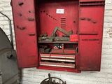 une armoire rouge contenant des outils, dans une pièce