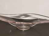 a glass bowl sitting on a table with a white wall in the background