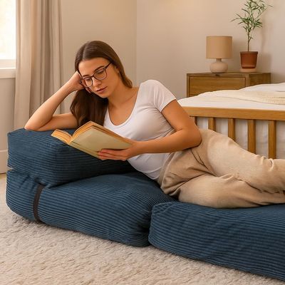 a woman reading a book on the floor of a bedroom