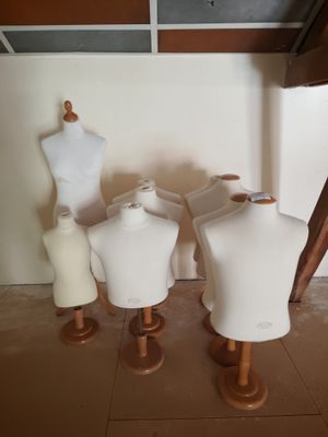 several mannequins are lined up on wooden stands in a room