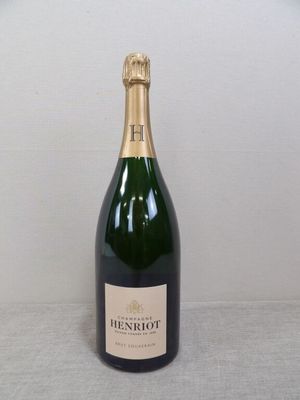La bouteille de champagne est posée sur la table près du mur.