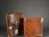 two pieces of brown leather luggage sitting next to each other