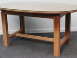 une photo d'une table en bois avec un plateau en verre, posée sur un sol recouvert de moquette
