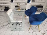 two blue chairs and a glass table in a room